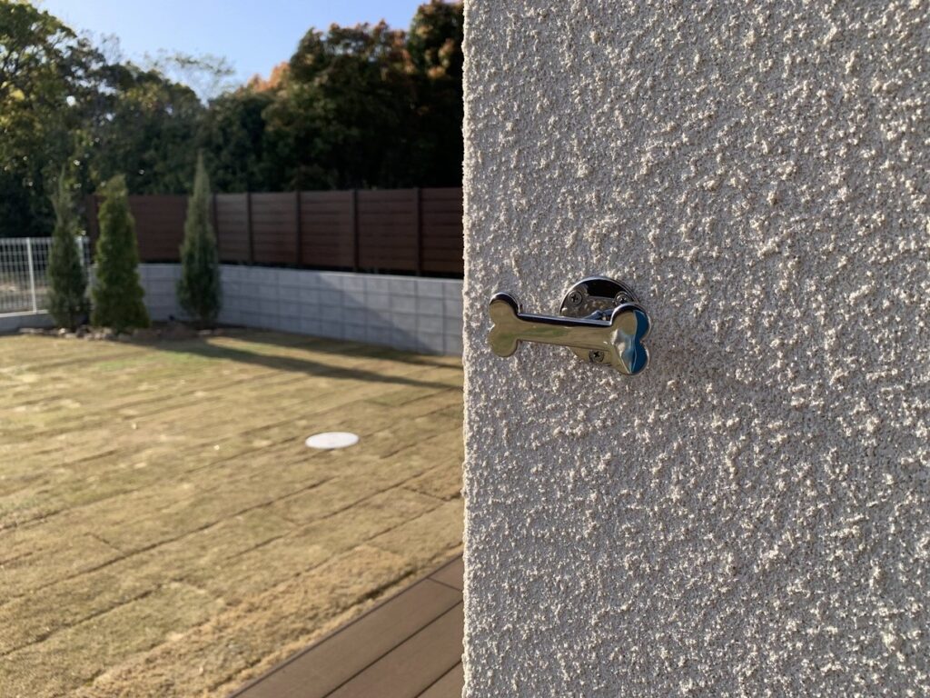 骨の形をした屋外フックと芝生の庭が広がる景色