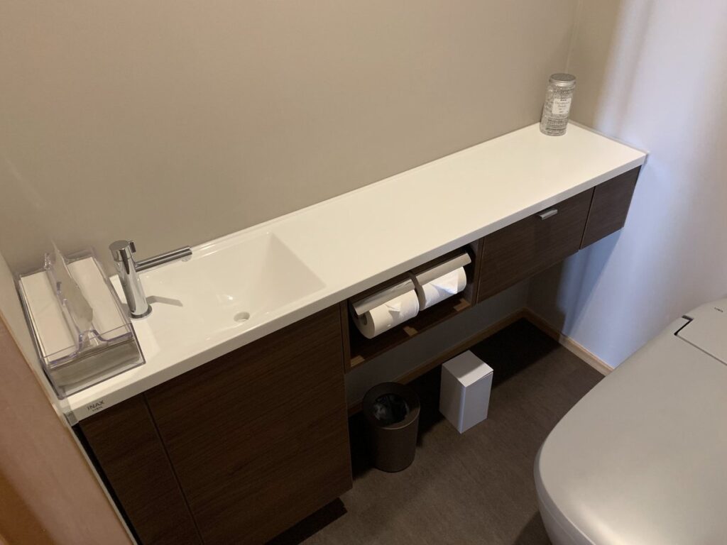 シンプルで機能的な手洗いカウンター付きトイレ空間